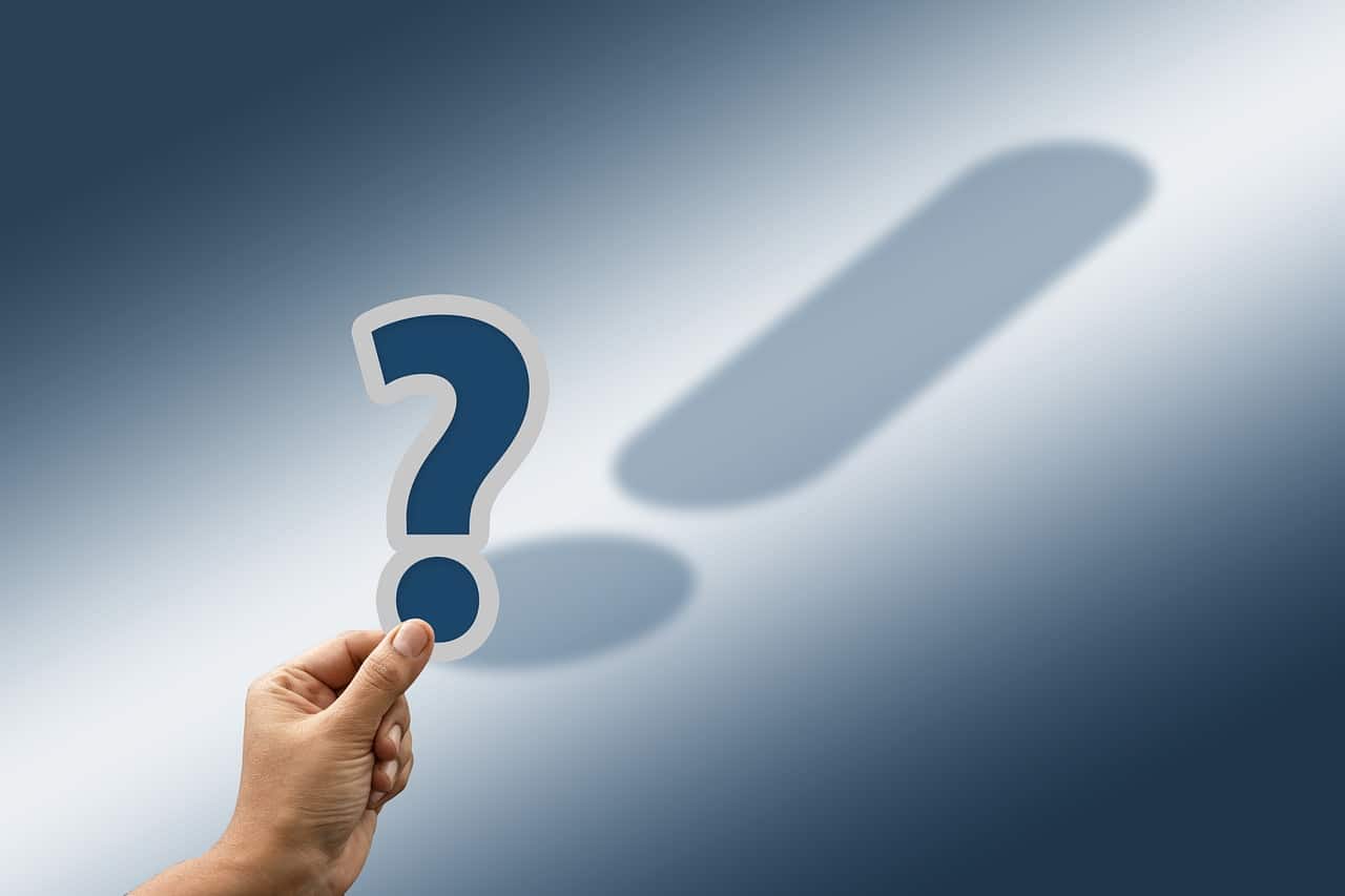 main qui tient un point d'interrogation et qui a comme ombre un point d'exclamation