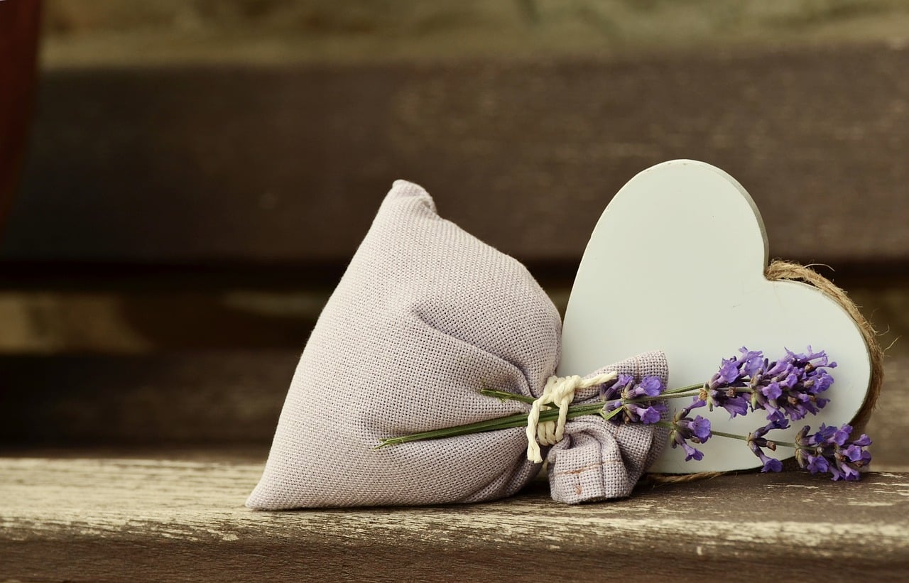 sachet remplie + lavande + coeur en bois posé sur une table