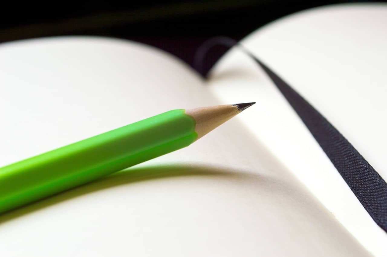 cahier avec un crayon à papier vert dessus
